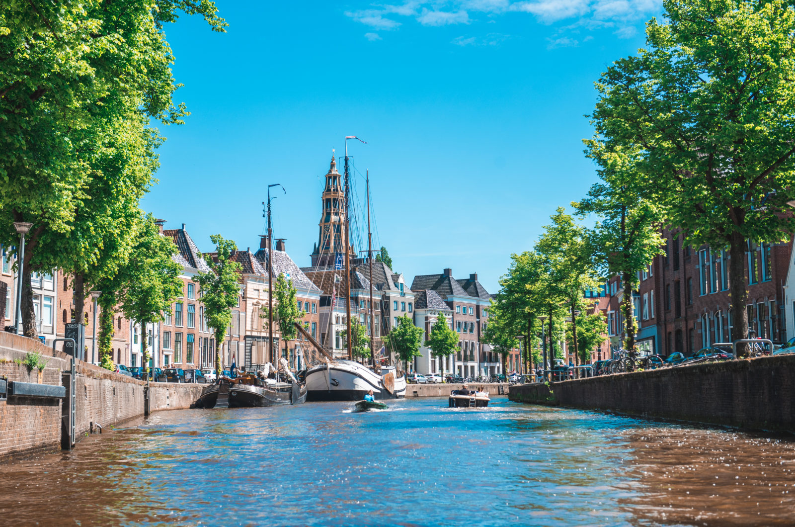 Bootjes in een boomrijke gracht in Groningen op een zonnige dag